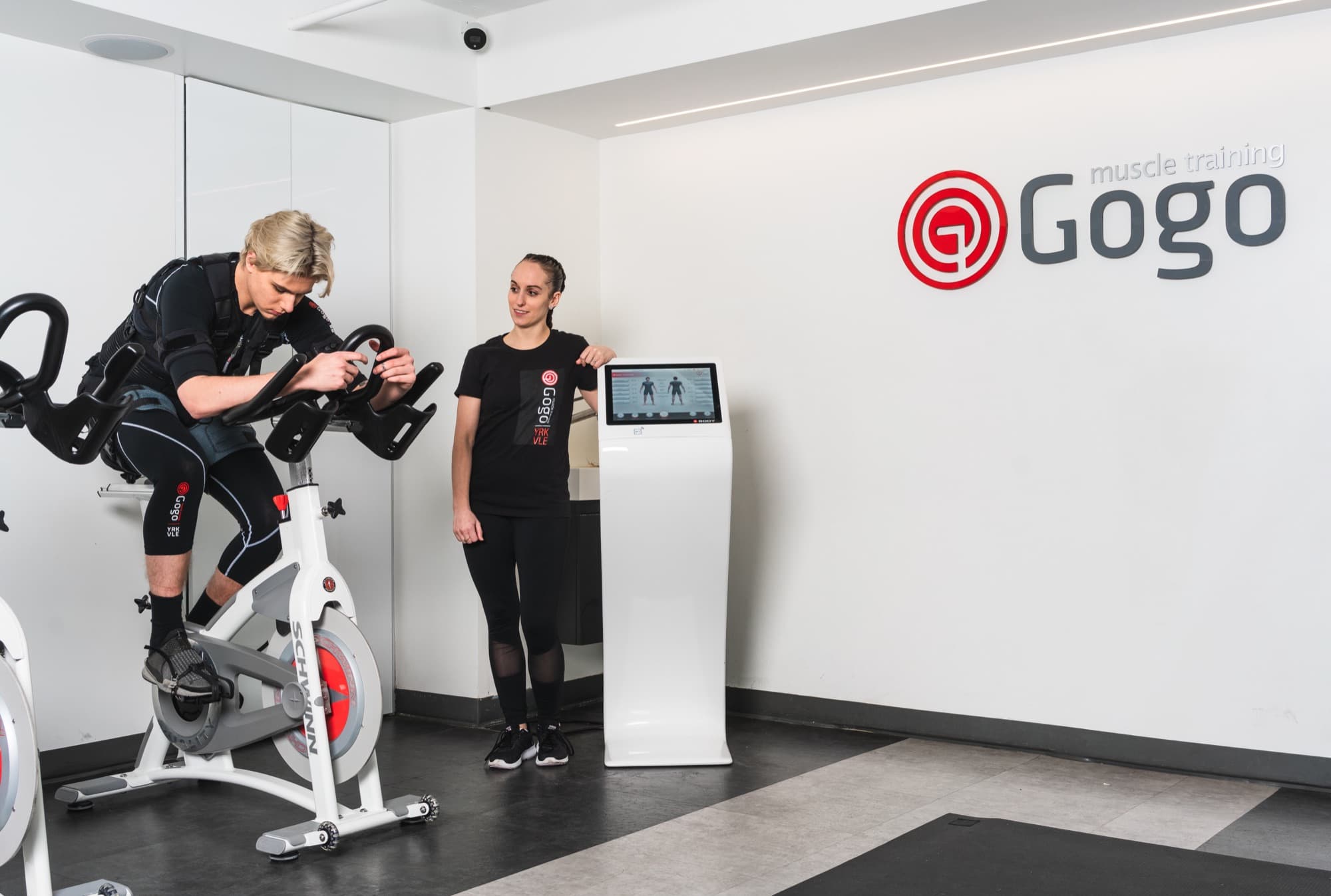 A client on a spin bike during an EMS cardiovascular session with a certified trainer at GoGo Muscle Training, Thornhill