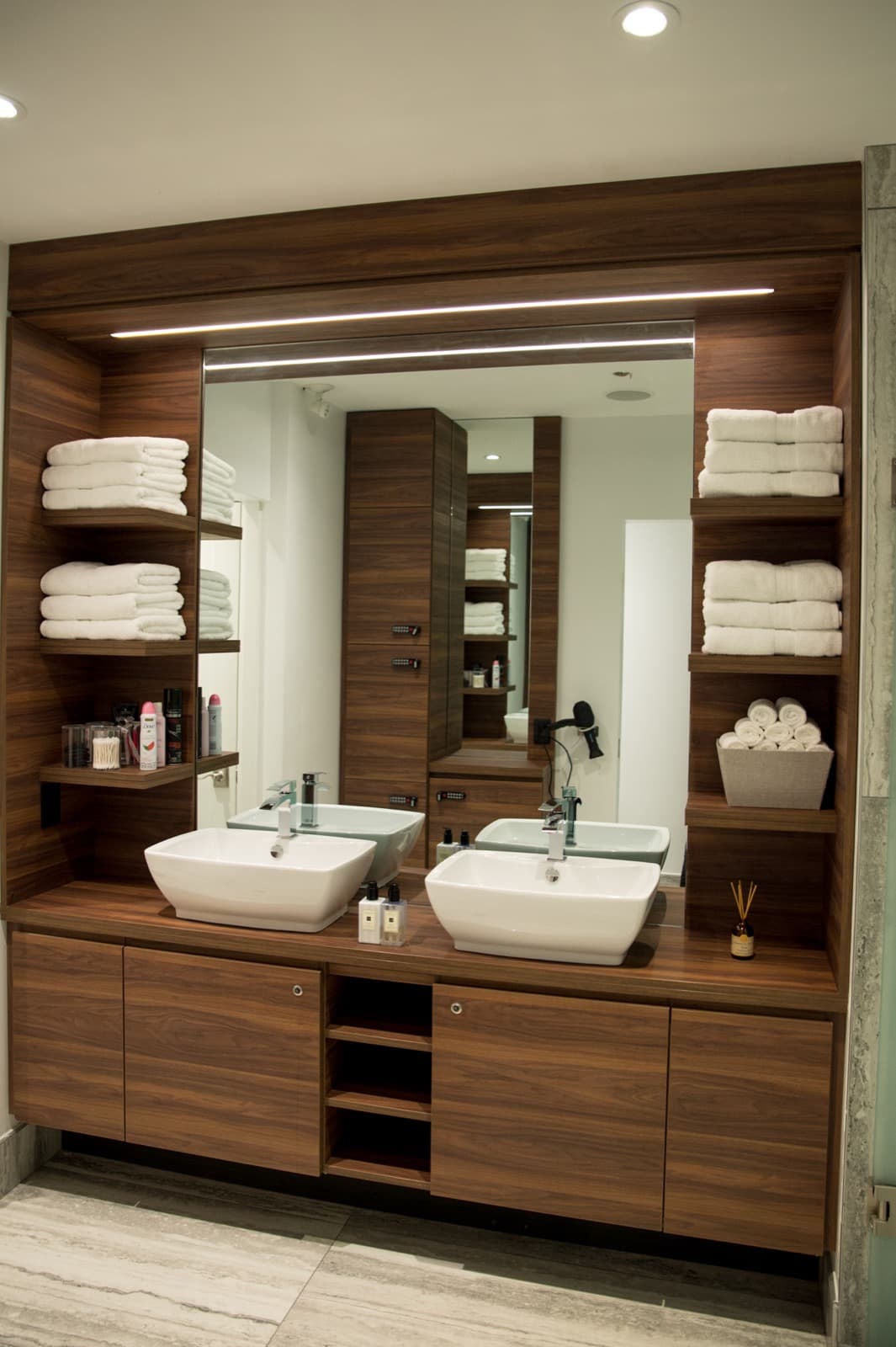 The premium double-vanity washroom with fresh towels and walnut joinery at GoGo Muscle Training