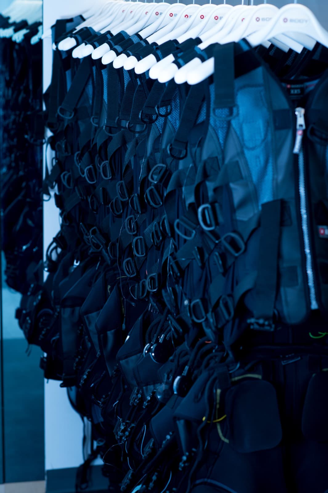 A rack of fitted XBody EMS suits prepped and laundered for the day's sessions