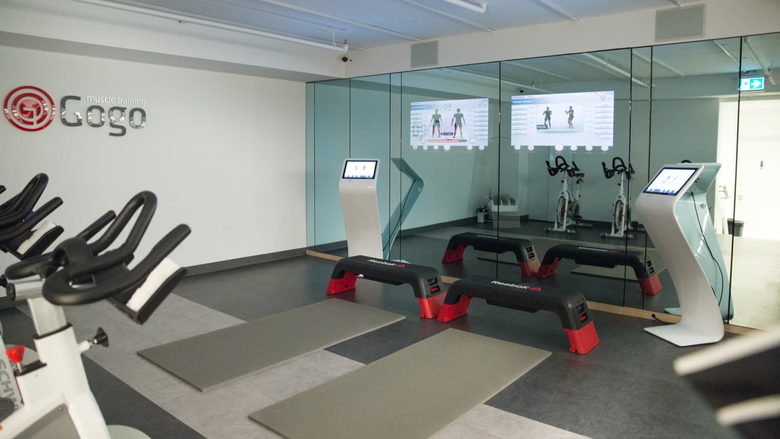 The EMS and cardio training floor with power plates, mats, and coaching screens