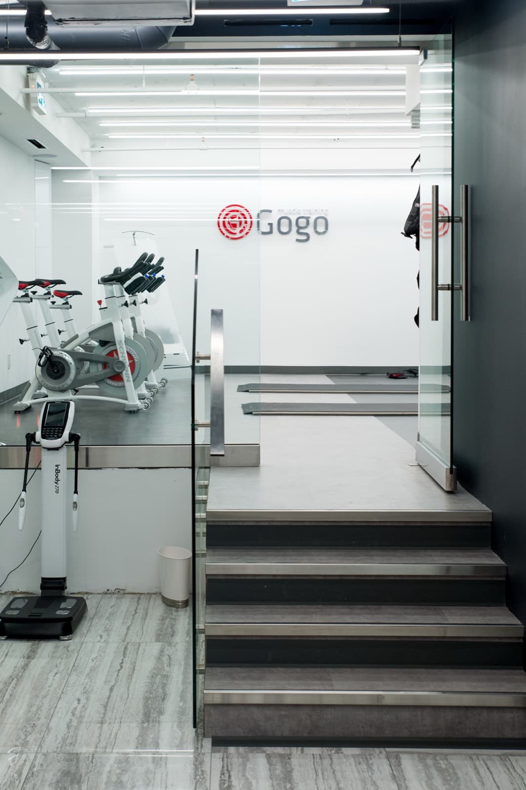 The glass-and-stone staircase connecting the training floors at the GoGo studio