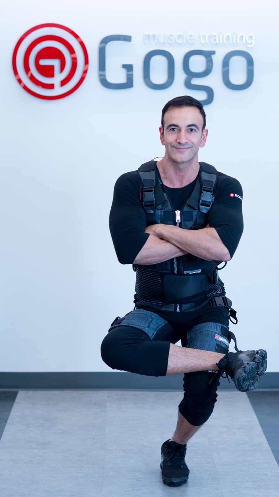 A client in a full EMS suit holding a lunge during a one-on-one training session